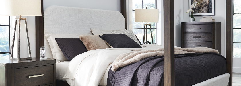 wood bed frame and dark blue bedding