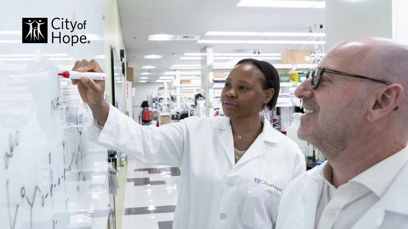 scientist writing on a whiteboard with City of Hope logo