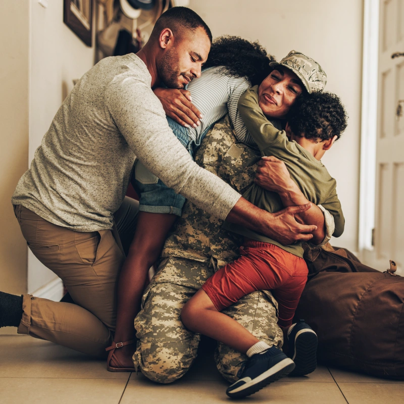 family hugging their mom who is in the military