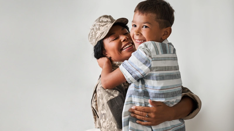 Military woman hugging kid