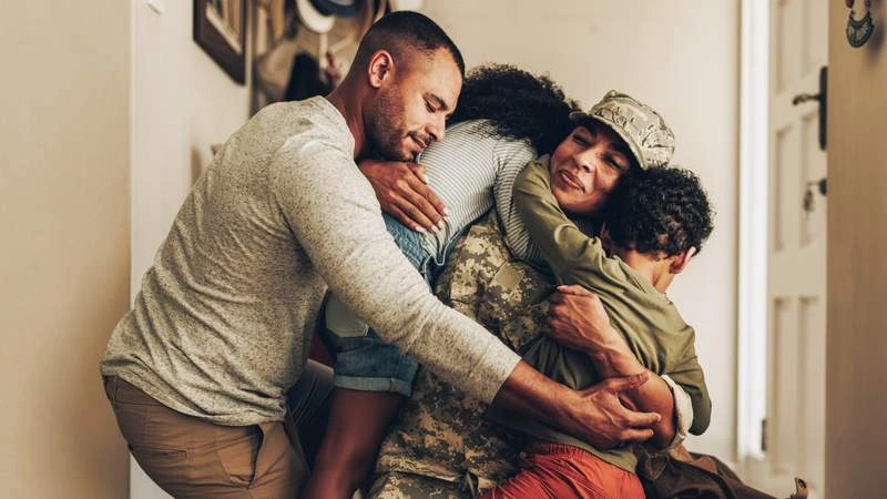 family hugging their mom that is in the military