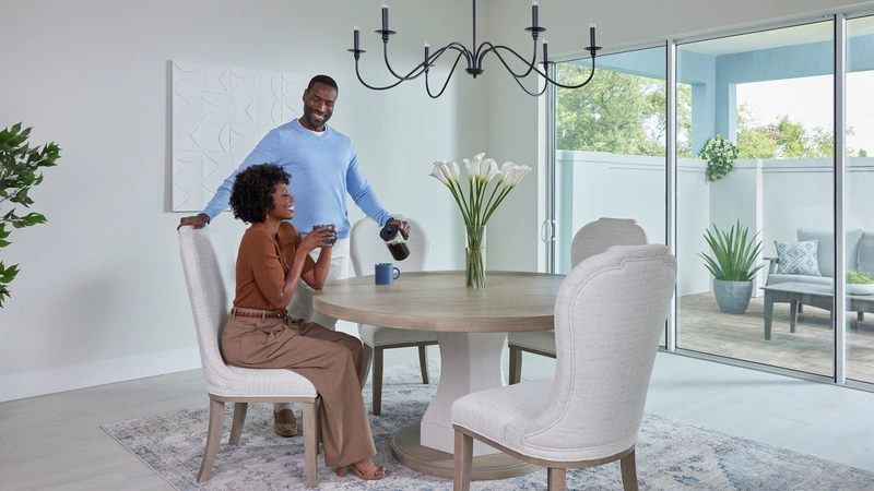 couple pouring coffee at dining table